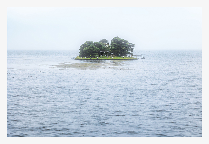島根・宍道湖に浮かぶ嫁ヶ島。夕日スポットとして有名な場所ですが、煙るように降る雨が、背景にある山や街並みを包み隠した湖の光景もまた幻想的。傘を持ちながらの手持ち撮影です。（F16・1/4秒・ISO100）